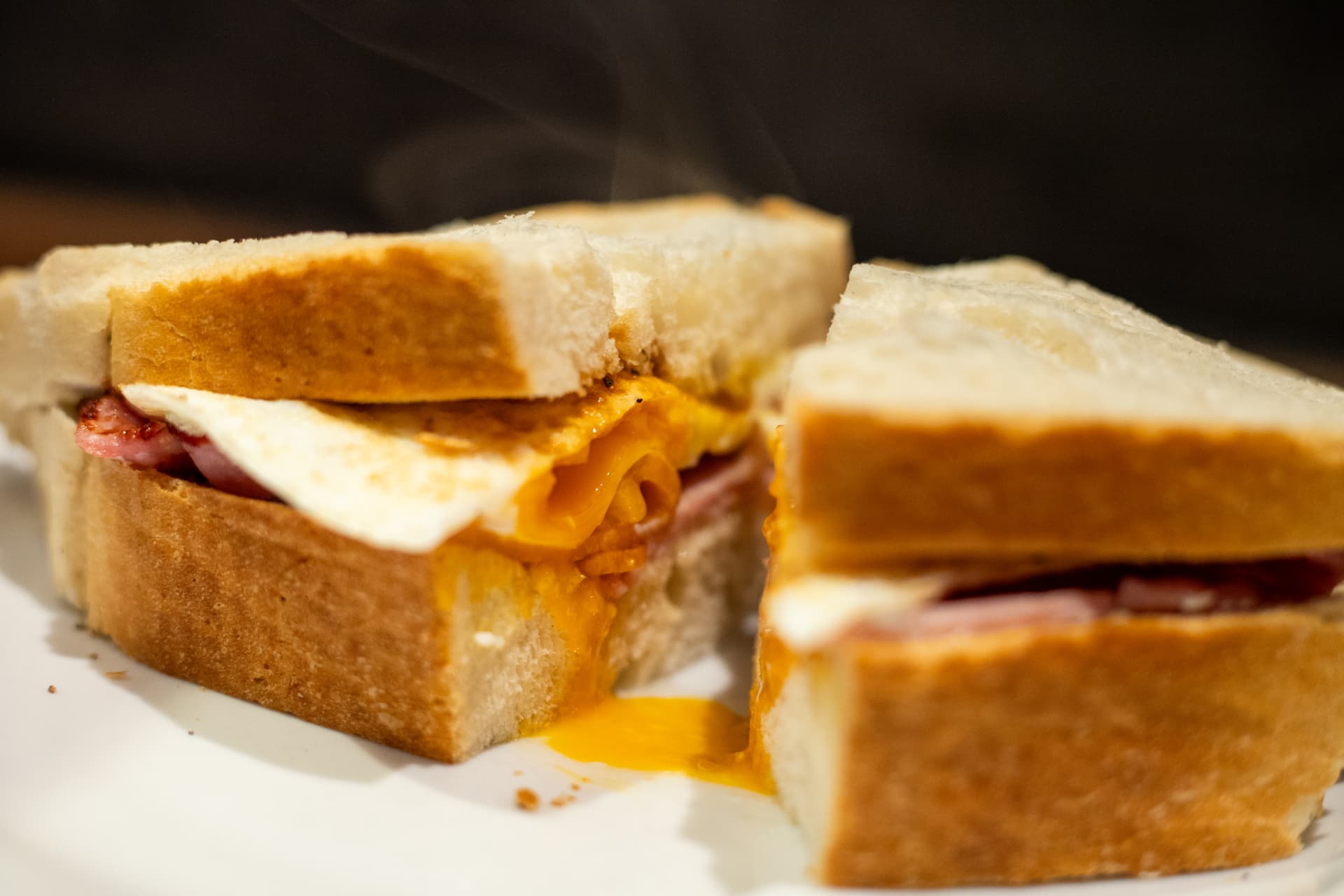 Hot bacon, egg and cheese sandwich on a plate